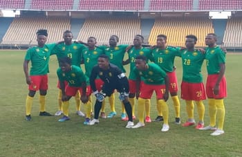 Groupe de joueurs camerounais en tenue de match sur le terrain.