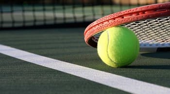 Balle de tennis et raquette sur le terrain de tennis.