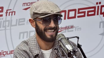 Nordo lors d'une interview en Algérie, portant un chapeau et des lunettes de soleil.