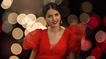 Lilia Bouyahiaoui en robe rouge avec fond de lumières floues.