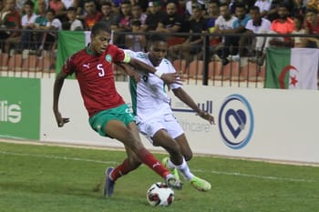 Deux joueurs de football en duel lors d'un match intense.