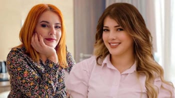 Deux femmes souriantes dans un cadre intérieur lumineux.