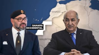 Deux hommes en discussion avec une carte du Sahara Occidental en arrière-plan.