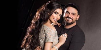 Jeune couple souriant, photo en studio, ambiance chaleureuse.