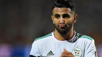 Footballeur algérien portant maillot blanc lors d'un match.