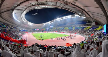 Stade Al Thumama au Qatar avec spectateurs et terrain de football.