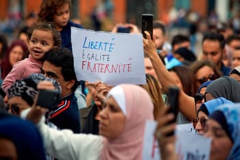 Manifestation avec un panneau 'Liberté, Égalité, Fraternité'.