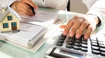 Personne utilisant une calculatrice pour évaluer un impôt sur les plus-values.
