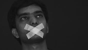 Jeune homme avec bouche recouverte de ruban adhésif noir.