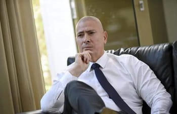 Homme en costume blanc pensant lors d'une réunion.