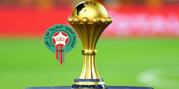 Trophée de la CAN 2025 sur un terrain de football.