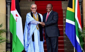 Deux dirigeants africains se serrent la main devant les drapeaux nationaux.