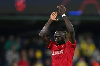Sadio Mané en action, portant le maillot de Liverpool, saluant le public.