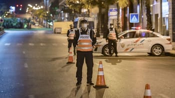 Policiers en contrôle sur une rue nocturne au Maroc.