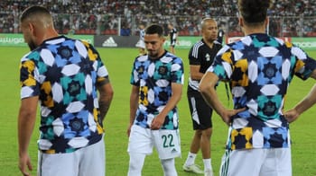 Joueurs de football avec maillots zellige colorés lors d'un match.
