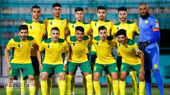 Groupe de joueurs de football algériens en tenue jaune et verte.