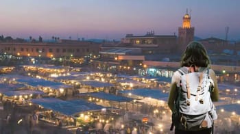 Jeune femme avec sac à dos à Marrakech au coucher du soleil.