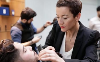 Femme barbière en action avec un client dans un salon de coiffure moderne.
