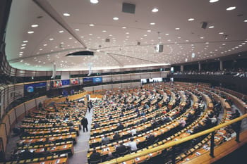Salle du Parlement européen avec députés et audience.