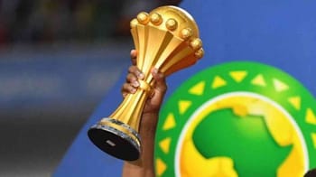 Trophée de la CAN 2025 avec un fond de logo africain.