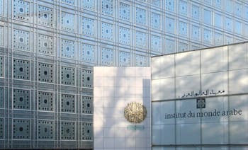 Façade moderne de l'Institut du Monde Arabe avec logo doré.