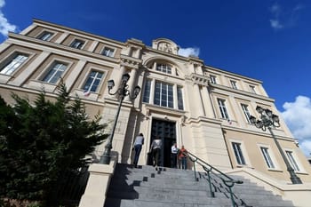 Immeuble historique avec escalier et lampadaires en fer forgé.