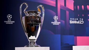 Trophée de la Ligue des Champions devant un fond de stade.