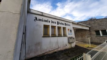 Bâtiment de l'Amicale des Pieds-Noirs à Mourenx avec fenêtres grillagées.