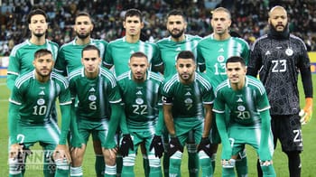 Groupe de joueurs d'Algérie en tenue verte sur le terrain.