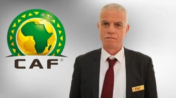 Homme en costume avec badge CAF devant le logo de la CAF.