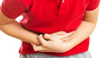 Jeune garçon souffrant de douleurs abdominales, tenant son ventre.