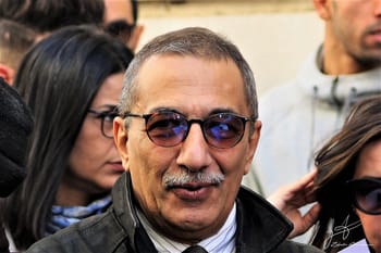 Homme portant lunettes foncées lors d'une manifestation ou rassemblement.