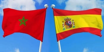 Drapeaux du Maroc et de l'Espagne flottant dans le ciel bleu.