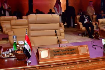 Salle de réunion avec un nom de table pour la Syrie et la Ligue arabe.