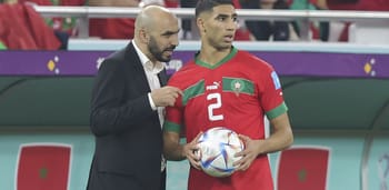 Walid Regragui parle à Achraf Hakimi lors d'un match de football.