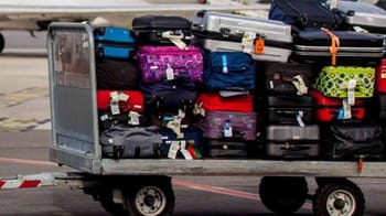 Bagages empilés sur un chariot à l'aéroport d'Alger.