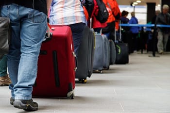 Passagers avec bagages en attente à l'aéroport.