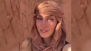 Jeune femme souriante avec foulard dans un décor en terre.