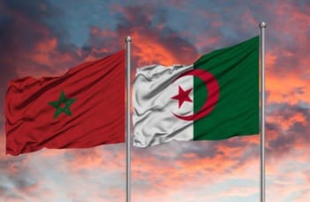 Drapeaux du Maroc et de l'Algérie flottant au coucher du soleil.