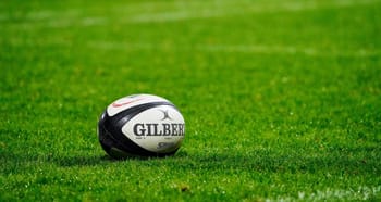 Ballon de rugby Gilber sur le terrain vert.