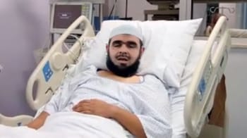 Imam Mahsas allongé dans un lit d'hôpital avec un bandage sur la tête.