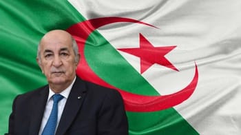 Homme politique algérien devant un drapeau national algérien.