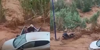 Homme sauvant sa famille lors d'une inondation en Algérie.
