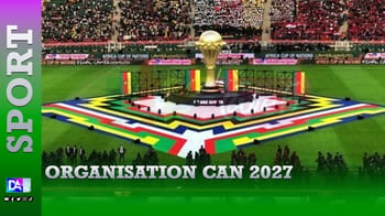 Stade de football avec trophée de la CAN 2027 au centre.