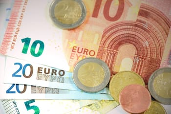 Billets et pièces de monnaie euro sur fond blanc.