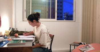 Femme étudiante travaillant à son bureau à domicile en soirée.