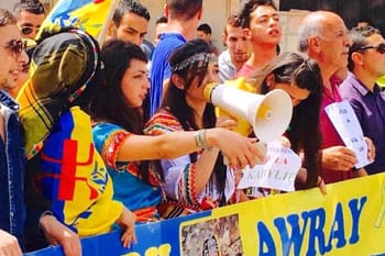 Jeunes Kabyles lors d'une manifestation avec un mégaphone et des banderoles.