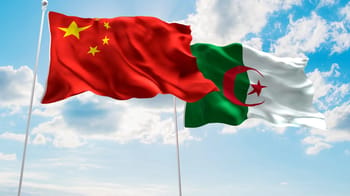 Drapeaux de la Chine et de l'Algérie flottant dans le ciel.