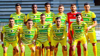 Groupe de joueurs de la JS Kabylie en tenue de match sur le terrain.