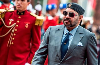 Homme en costume avec lunettes de soleil lors d'une parade officielle.